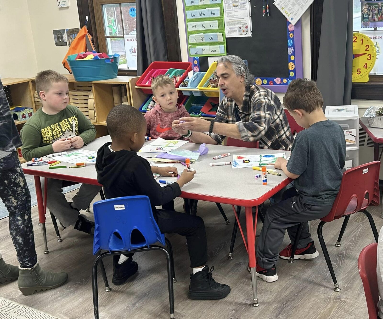 A teacher helping children with an art project