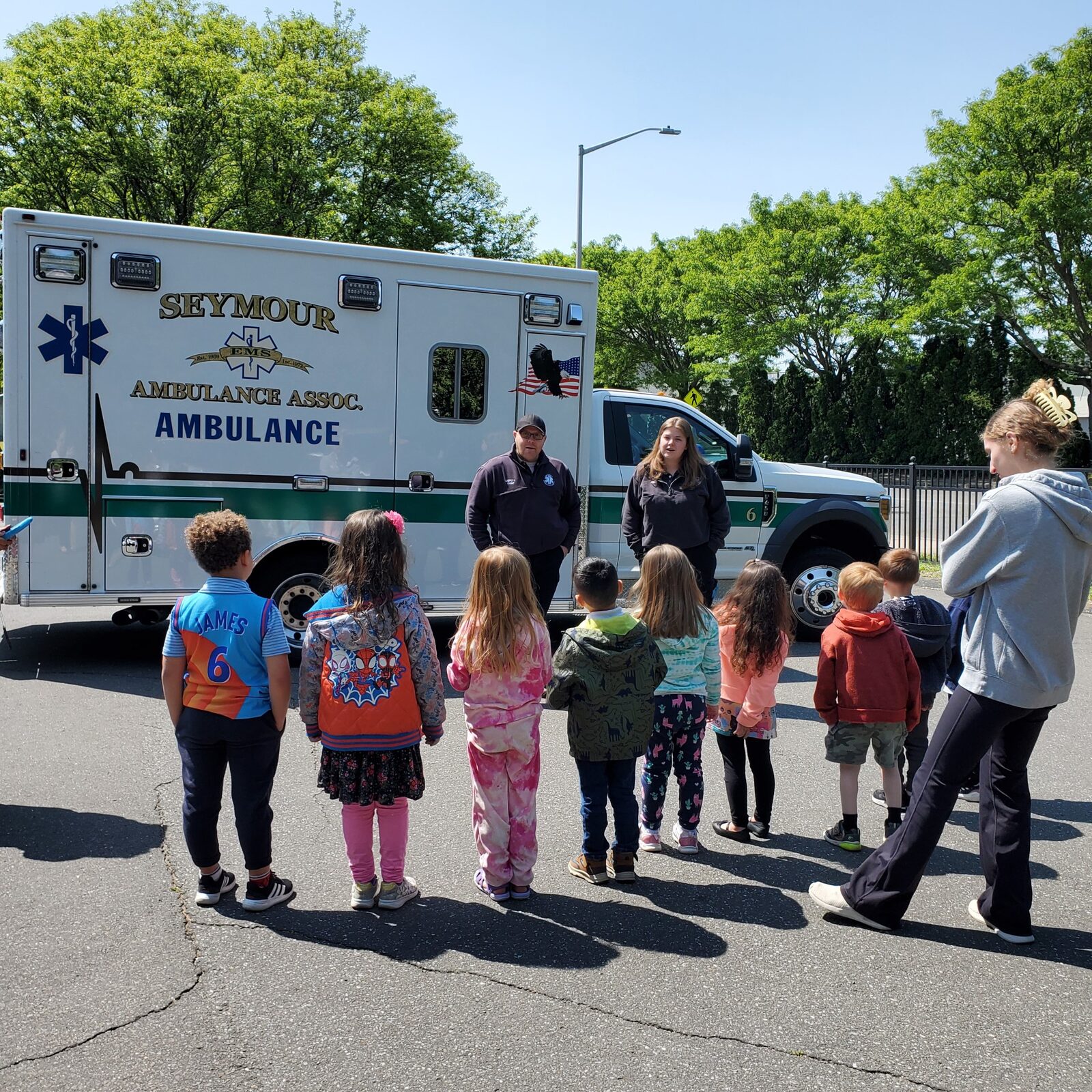 Children meeting paramedics beside an ambulance during Community Helpers Week