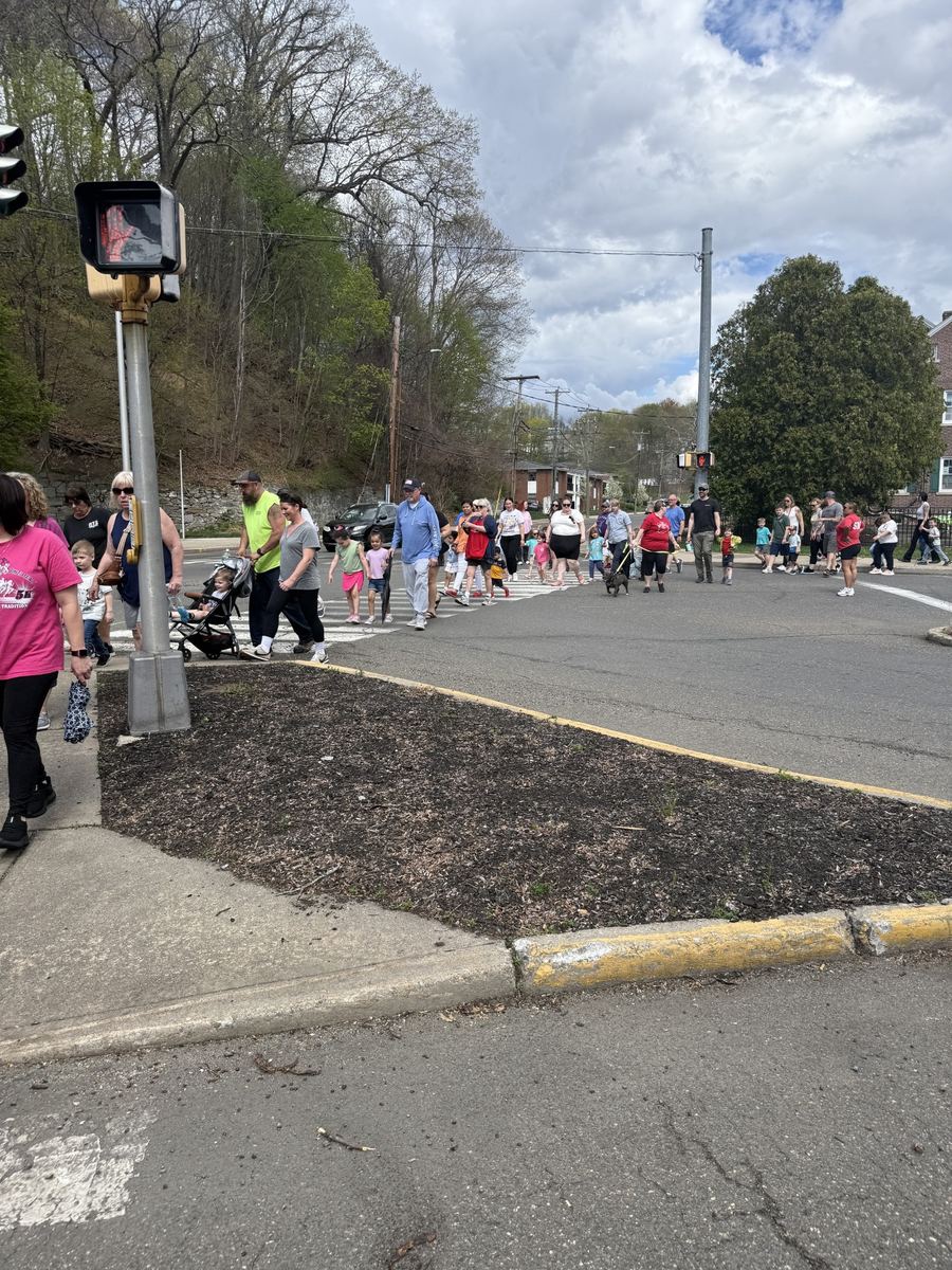 A long line of families and children crossing a street in Ansonia on the Family Walk