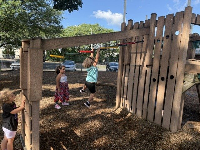 Children climbing on the wooden playground structure