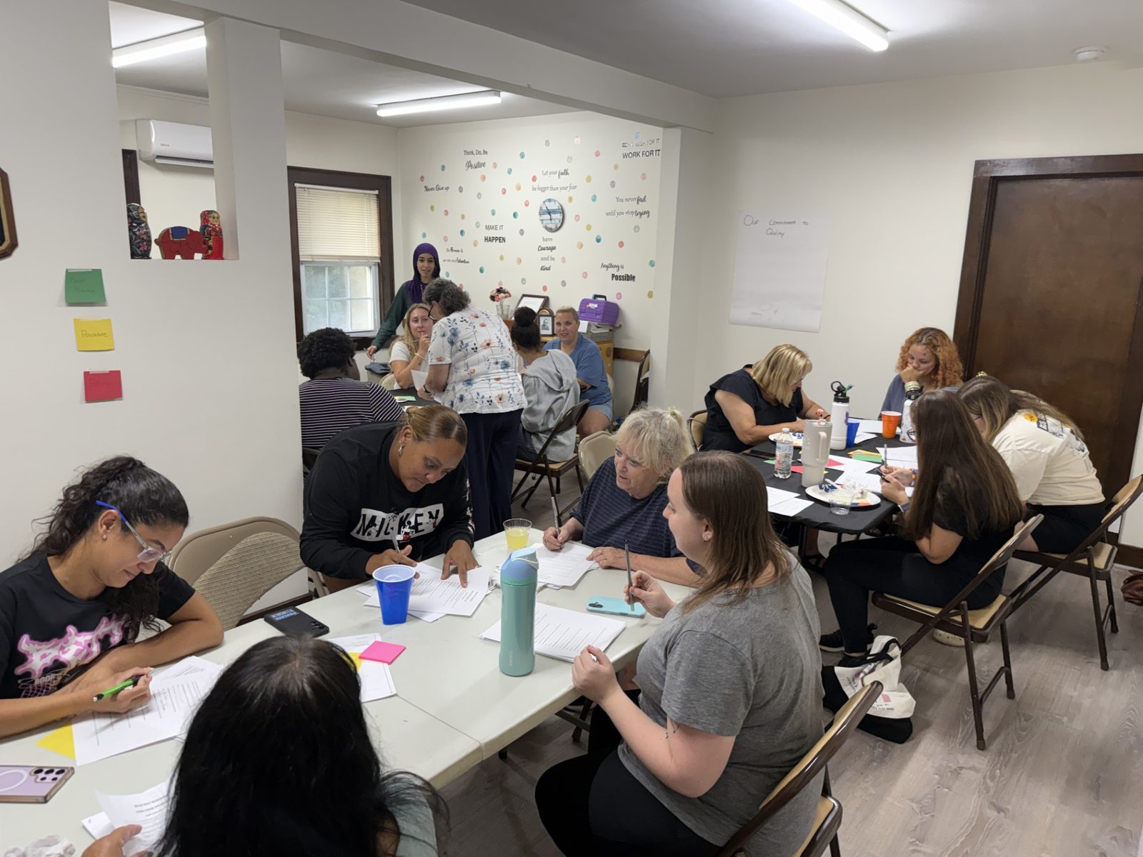 Teachers seated around tables in a classroom during a continuing-education session